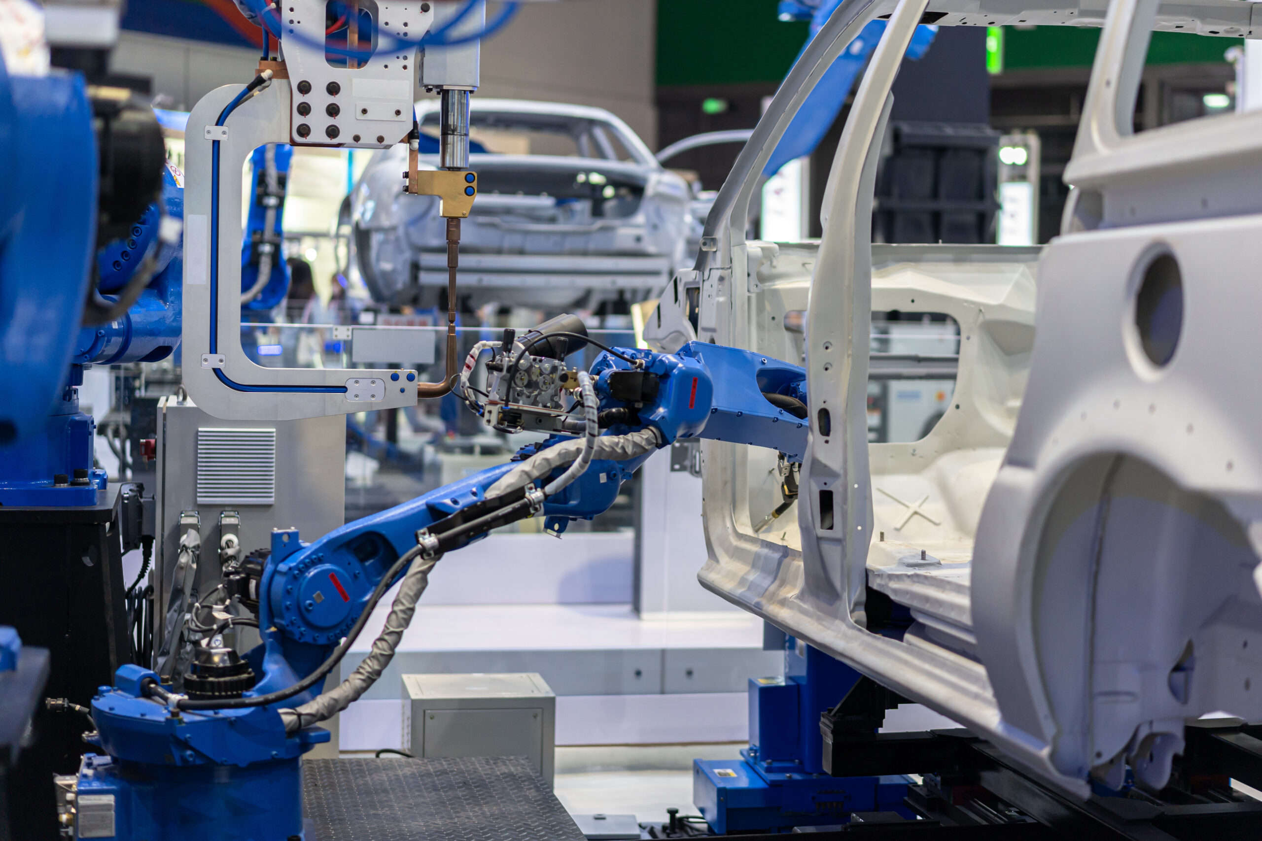 Secteur d'activité : Tous les moteurs vendus par la Société SMH qui sont utilisés pour : Rétroviseurs électriques, sièges réglables, POMPES LAVE-GLACE Robot bleu électrique, dans une usine de fabrication d'automobiles, qui visse à l'intérieur de la carcasse de l'automobile blanche